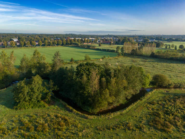 Luchtfoto met op de voorgrond de door het buitengebied van Bergeijk slingerende beek de Keersop. Op de achtergrond is de dorpskern Westerhoven te zien.